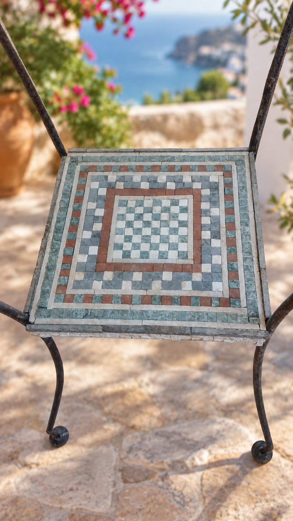 Close-up of the decorative shelf board beneath the tabletop, concentric mosaic pattern in green, cream, and red stone